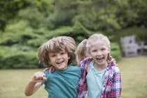 Glücklich lächelnde Kinder, die sich im Freien umarmen — Stockfoto