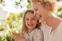 Mother and daughter laughing outdoors — Stock Photo