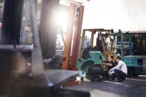 Carretilla elevadora de fijación mecánica en taller de reparación de automóviles - foto de stock
