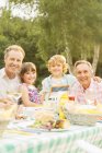 Família de várias gerações almoçando à mesa no quintal — Fotografia de Stock