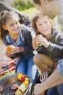 Father and kids eating hamburgers at barbecue grill — Stock Photo