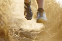 Close up of runner?s feet on dirt trail — Stock Photo