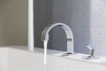 Closeup of water emitting from modern faucet — Stock Photo