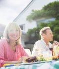 Happy smiling woman at table in backyard — Stock Photo