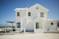 Casa de praia branca contra o céu azul — Fotografia de Stock