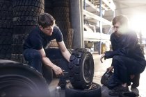 Mechanics fixing tire in auto repair shop — Stock Photo