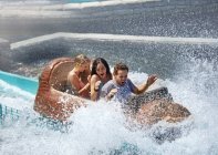 Des amis se font éclabousser dans un parc d'attractions en rondins d'eau — Photo de stock