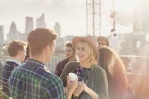 Young man and woman drinking and talking at rooftop party — Stock Photo