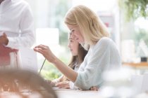 Frau liest Menü am Cafétisch — Stockfoto