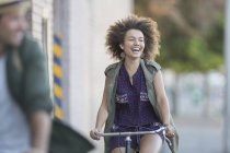 Femme enthousiaste avec afro vélo d'équitation — Photo de stock