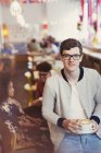 Porträt lächelnder Mann mit Brille trinkt Cappuccino im Café — Stockfoto