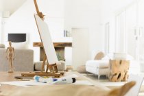 Easel and paint tubes on table — Stock Photo