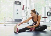 Женщина растягивает ногу в спортзале — стоковое фото