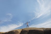 Человек, стоящий на скале — стоковое фото