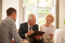 Financial advisor talking to couple in living room — Stock Photo
