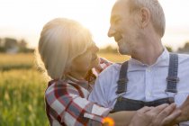 Close up affectionate senior couple hugging in rural field — Stock Photo