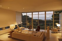 Moderna sala de estar con vistas a los árboles y la ciudad en distancia - foto de stock