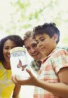 Family watching butterfly in jar — Stock Photo