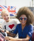 Ritratto amici entusiasti con bandiera britannica in autobus a due piani — Foto stock