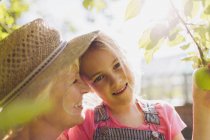 Ritratto sorridente nipote con nonna in giardino soleggiato — Foto stock