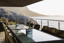 Table à manger sur patio de luxe surplombant l'océan — Photo de stock