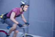 Mensajero de bicicleta enfocado con casco en movimiento - foto de stock