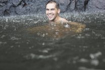 Дождь, падающий на человека в озере — стоковое фото