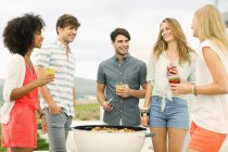 Jeunes amis heureux parlant au barbecue — Photo de stock