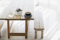 Placas e talheres empilhados em mesa de madeira — Fotografia de Stock