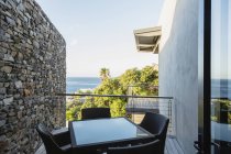Mesa e cadeiras na varanda de luxo com vista para o oceano — Fotografia de Stock
