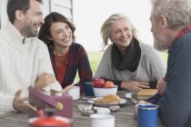 Couples talking and enjoying breakfast at patio table — Stock Photo