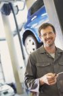 Portrait mécanicien confiant dans l'atelier de réparation automobile — Photo de stock