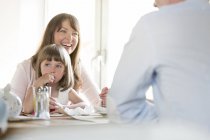 Семья сидит за столом кафе в помещении — стоковое фото