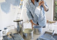 Woman holding paintbrush with blue paint — Stock Photo