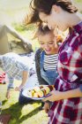 Mother and daughter with vegetable skewers at campsite — Stock Photo