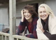 Portrait smiling mother and daughter on windy porch — Stock Photo