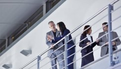 Geschäftsleute reden am Geländer im Büro — Stockfoto