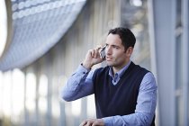 Успешный взрослый бизнесмен разговаривает по мобильному телефону на открытом воздухе — стоковое фото