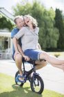 Couple chevauchant petit vélo dans l'herbe — Photo de stock