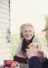 Sorridente coppia anziana parlando al tavolo patio — Foto stock