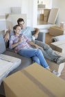 Couple relaxing with coffee on sofa in new house — Stock Photo