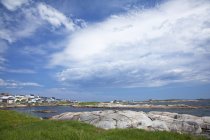 Blue sky and clouds over craggy harbor — Stock Photo