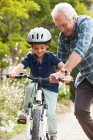 Grandfather teaching grandson to ride bicycle — Stock Photo
