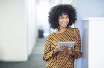 Портрет женщины с помощью цифрового планшета в офисе — стоковое фото