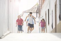 Children playing soccer in alley — Stock Photo