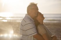 Взрослая пара, обнимающаяся на пляже — стоковое фото