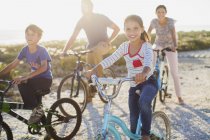 Family riding bicycles on sunny beach — Stock Photo