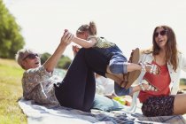 Verspielte Oma und Enkelin auf Decke im sonnigen Feld — Stockfoto