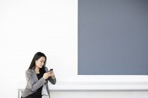 Successful adult businesswoman using cell phone in office — Stock Photo