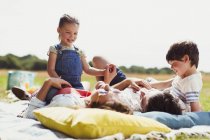 Семейный отдых на одеяле в солнечном поле — стоковое фото